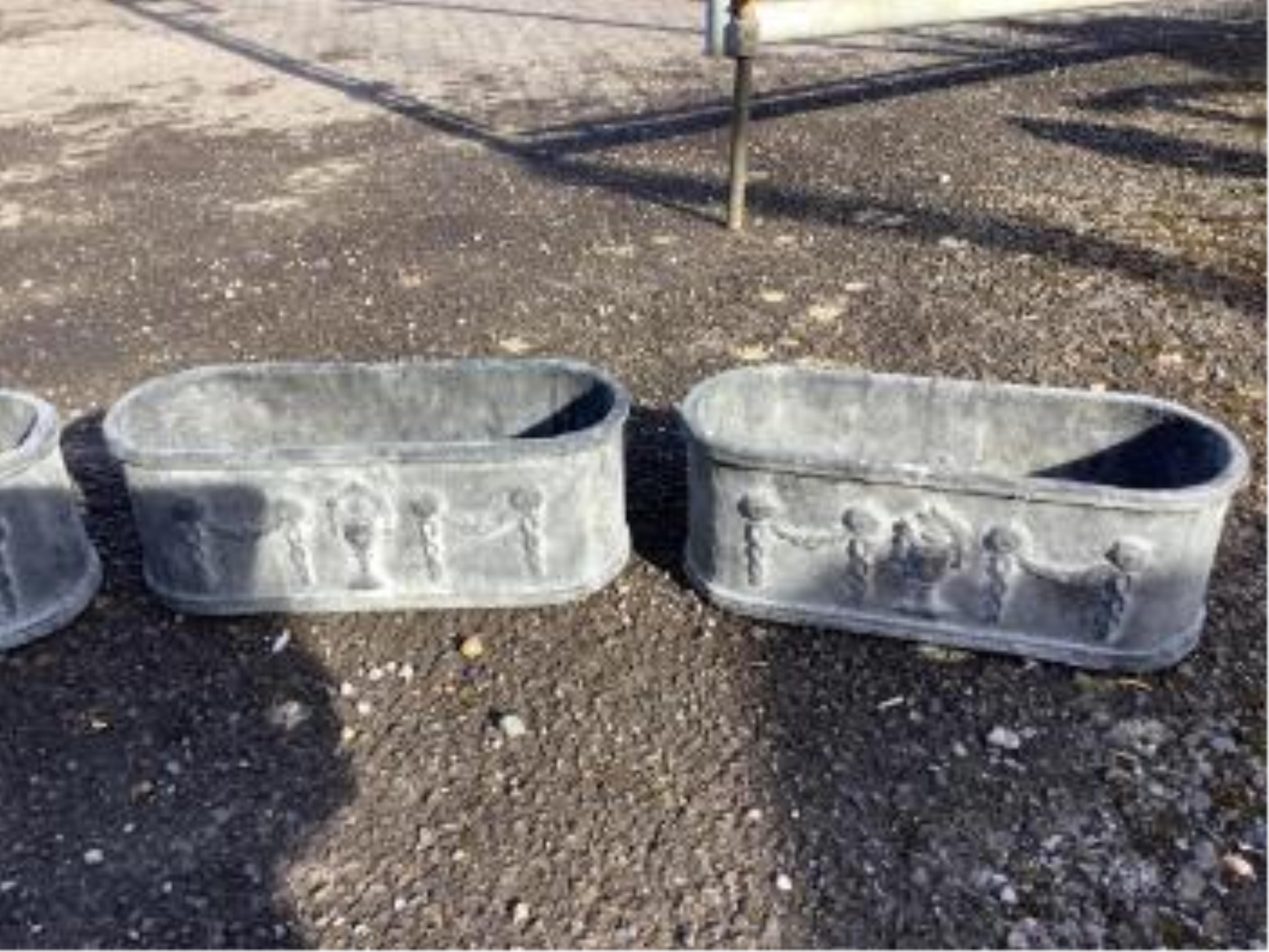 A set of four cast iron planters, width 36cm, and a pair of more ornate planters, width 48cm. Condition - weathered, otherwise good